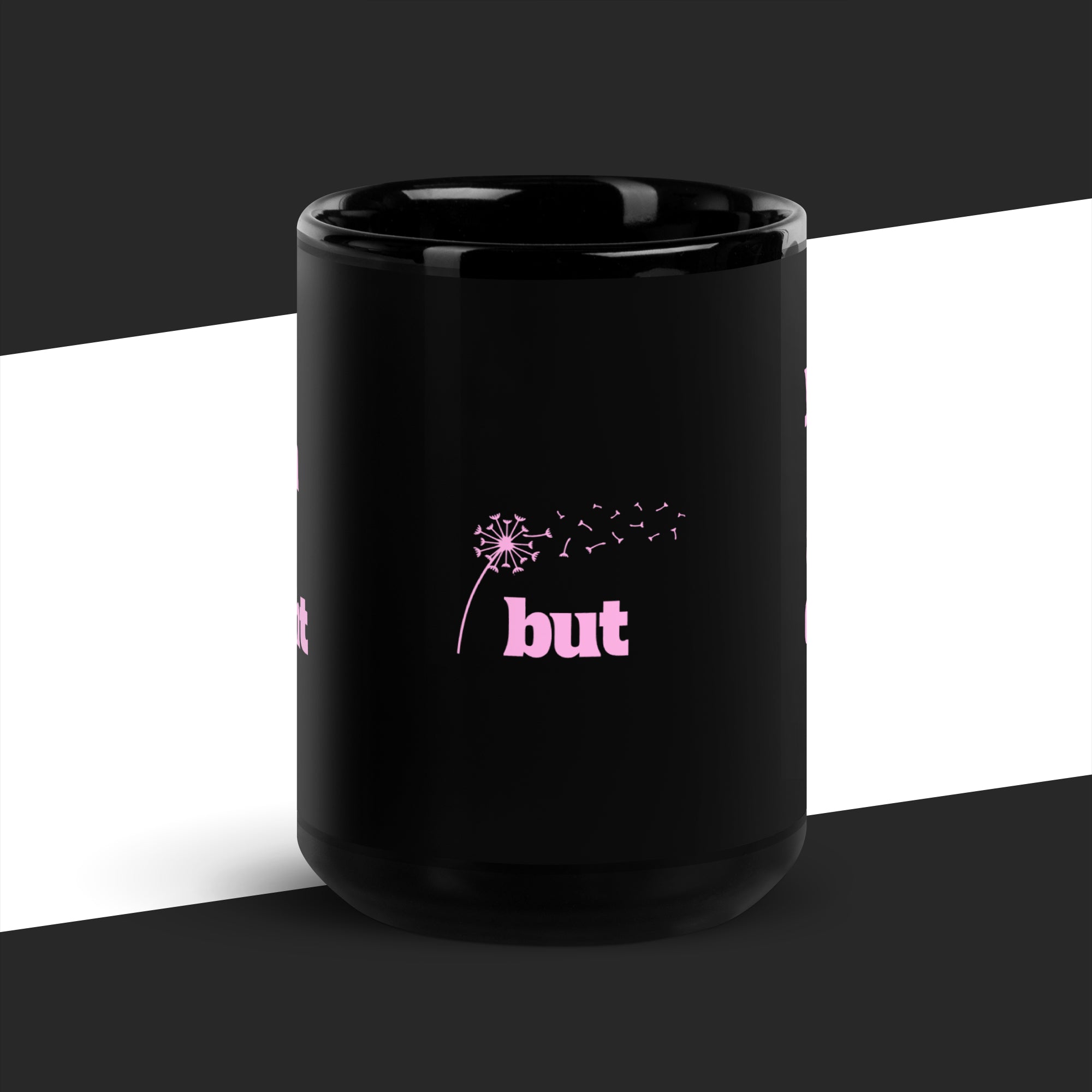 Black mug with pink text and dandelion graphic on a black and white background