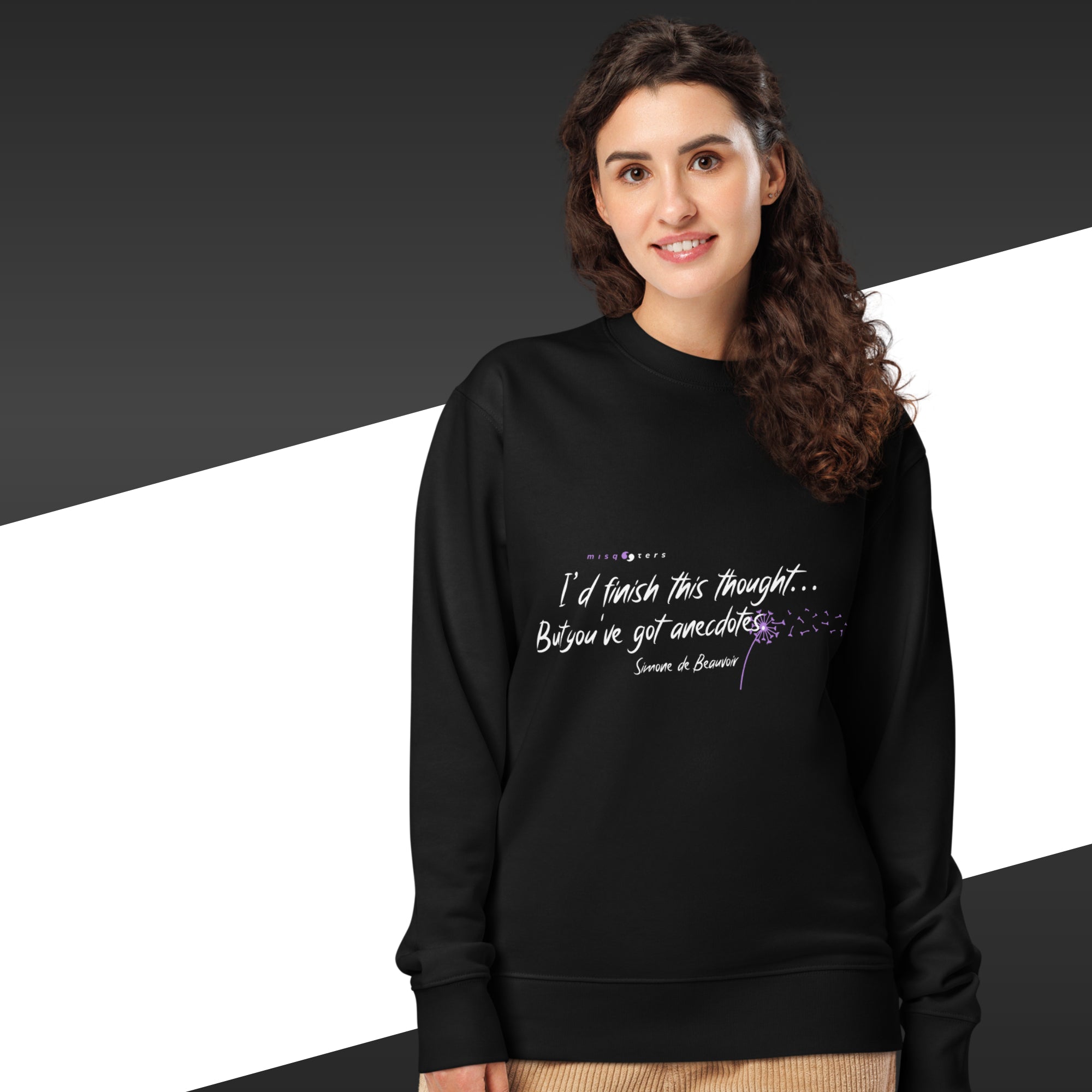 Woman with black sweatshirt with a white and purple quote from Simone de Beauvoir on it