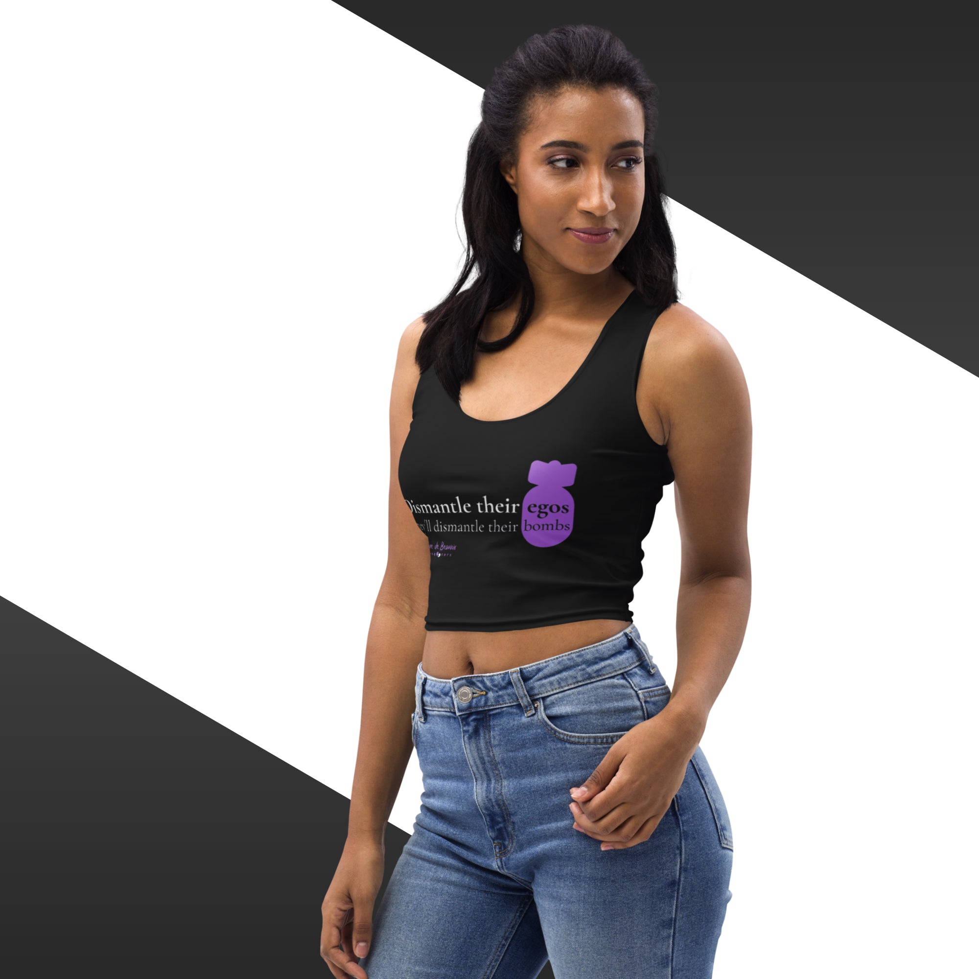 Woman wearing a black crop top with a graphic and text, standing against a geometric background.