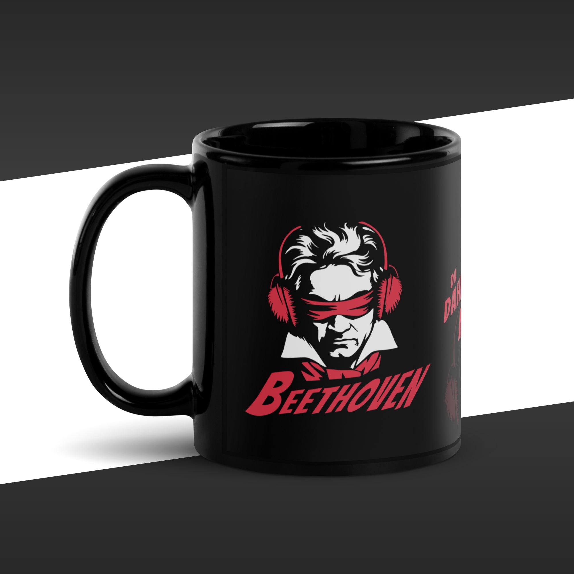 Black mug with a red and white graphic of Beethoven wearing ear protectors, is blidnfolded, and featuring the fake quote "I´m da Dahedevil ov moosic" by Beethoven