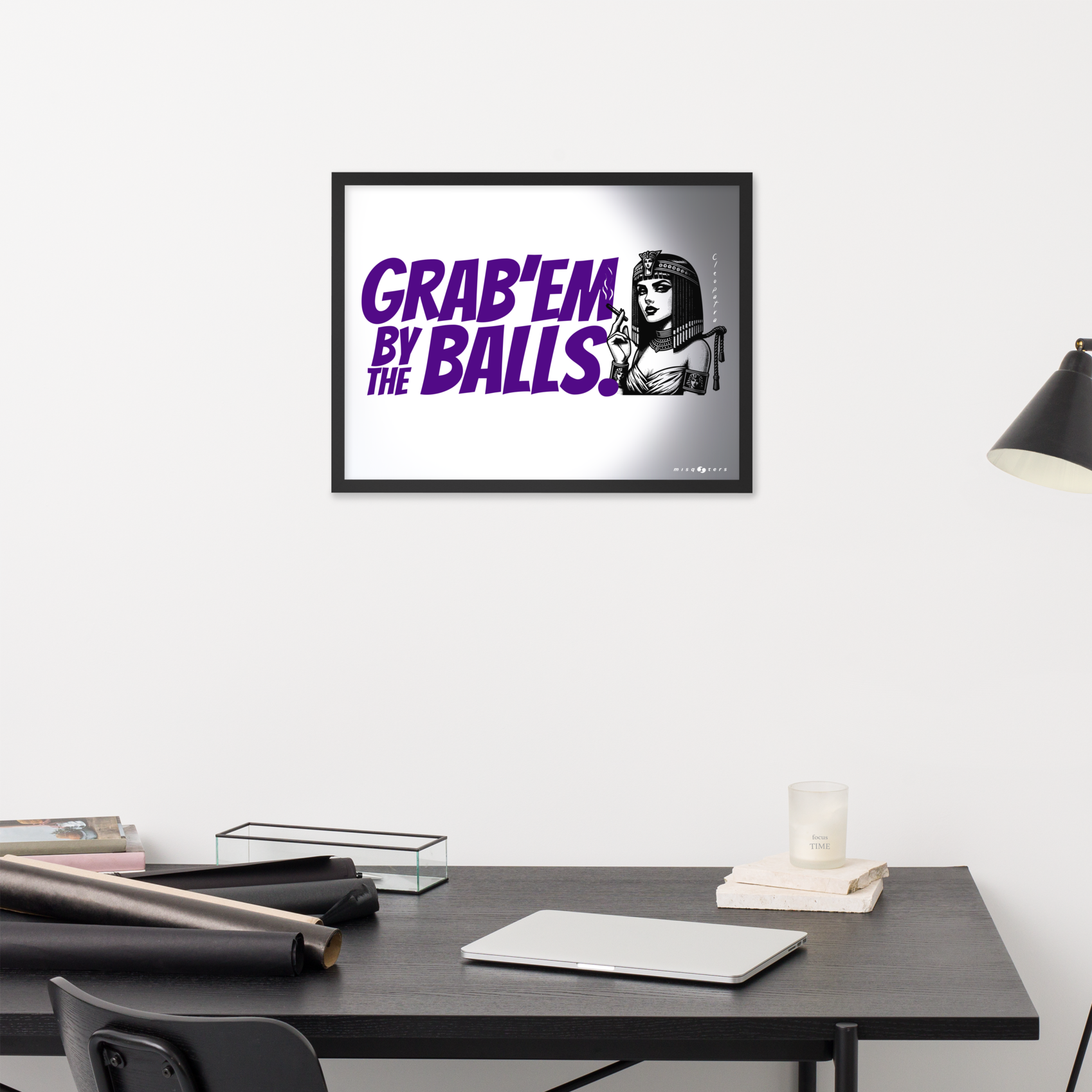 Framed artwork with a graphic design on a wall above a desk.