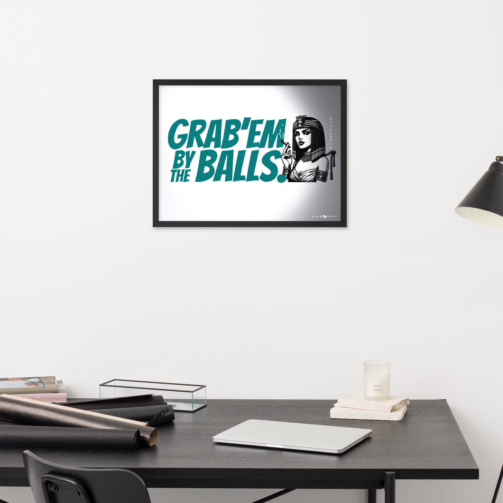 Framed poster with text and graphic on a wall above a desk.