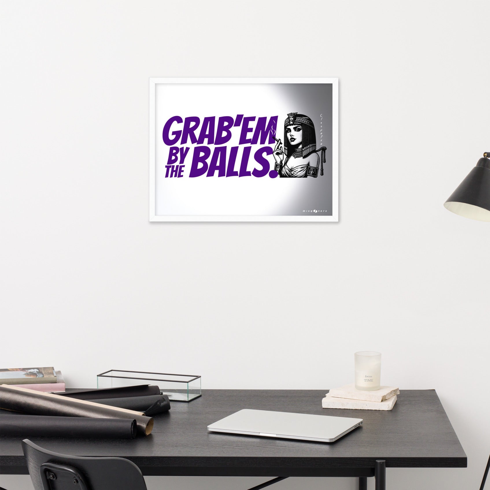 Framed artwork with a graphic design on a wall above a desk.