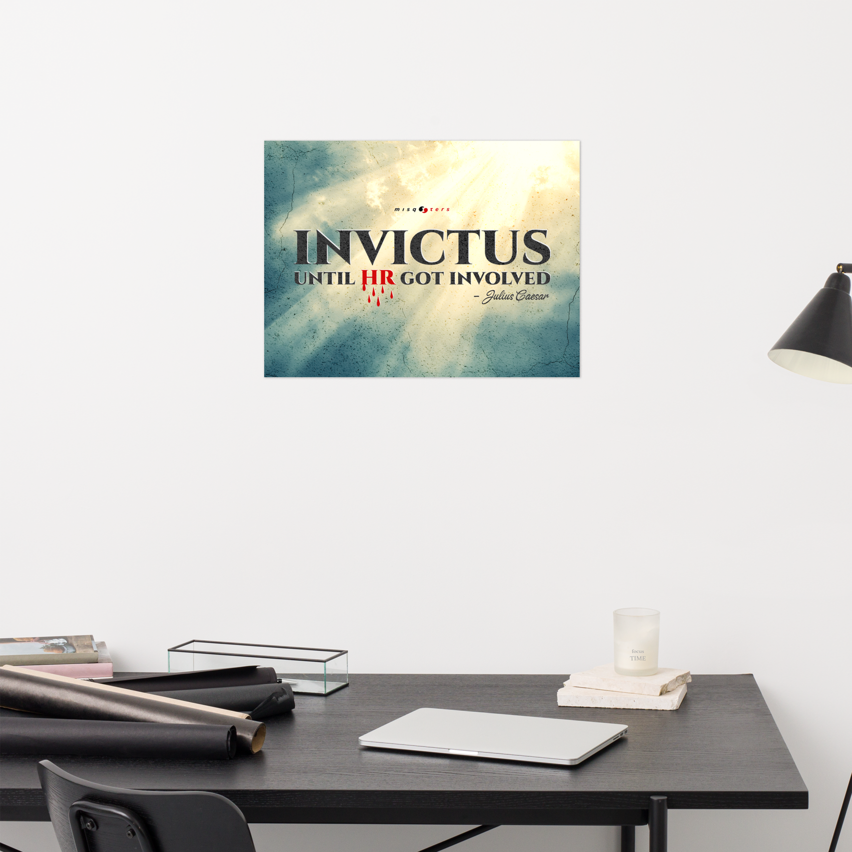 Desk with a motivational poster titled 'Invictus' on a white wall.