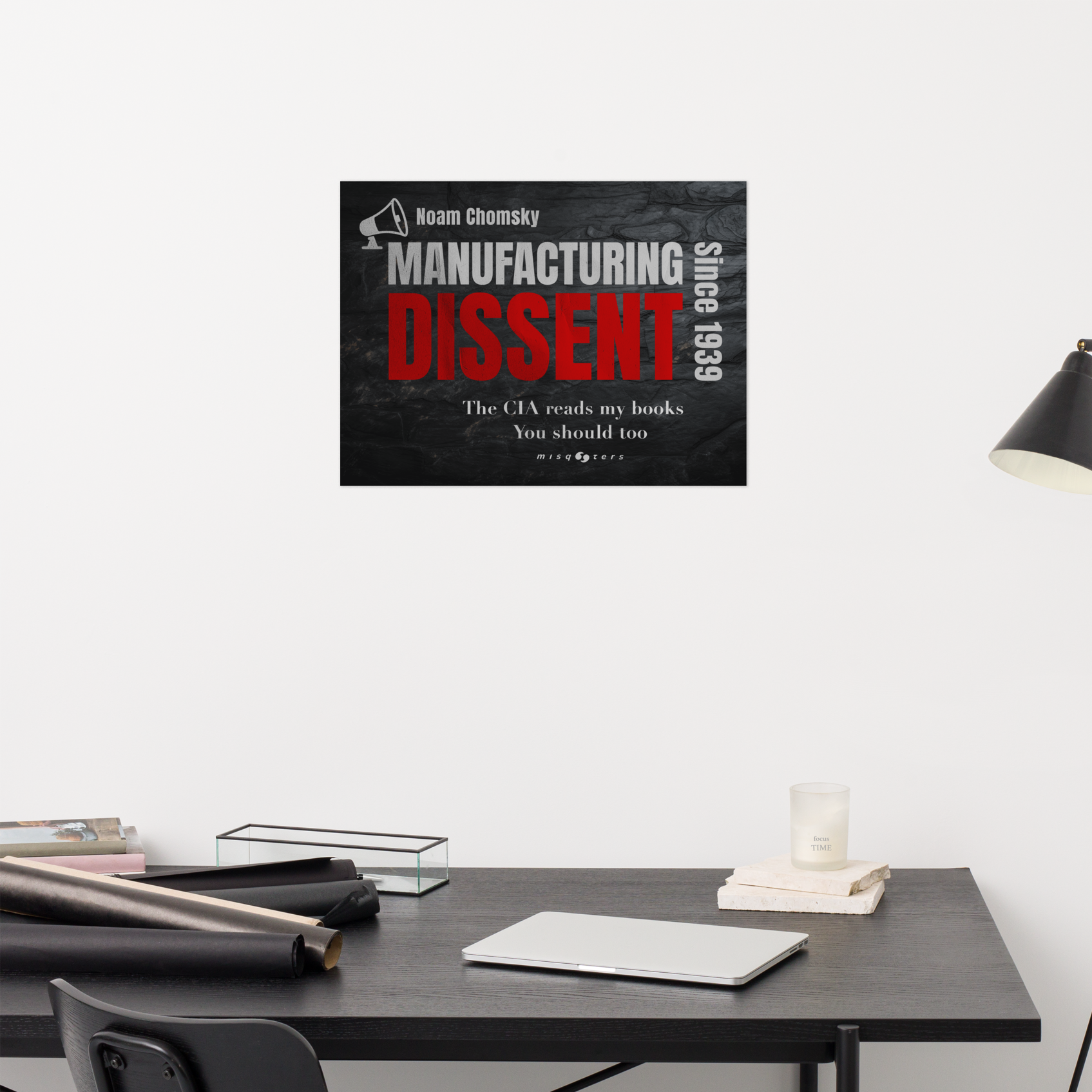 Poster of 'Manufacturing Dissent' by Noam Chomsky on a wall above a desk.