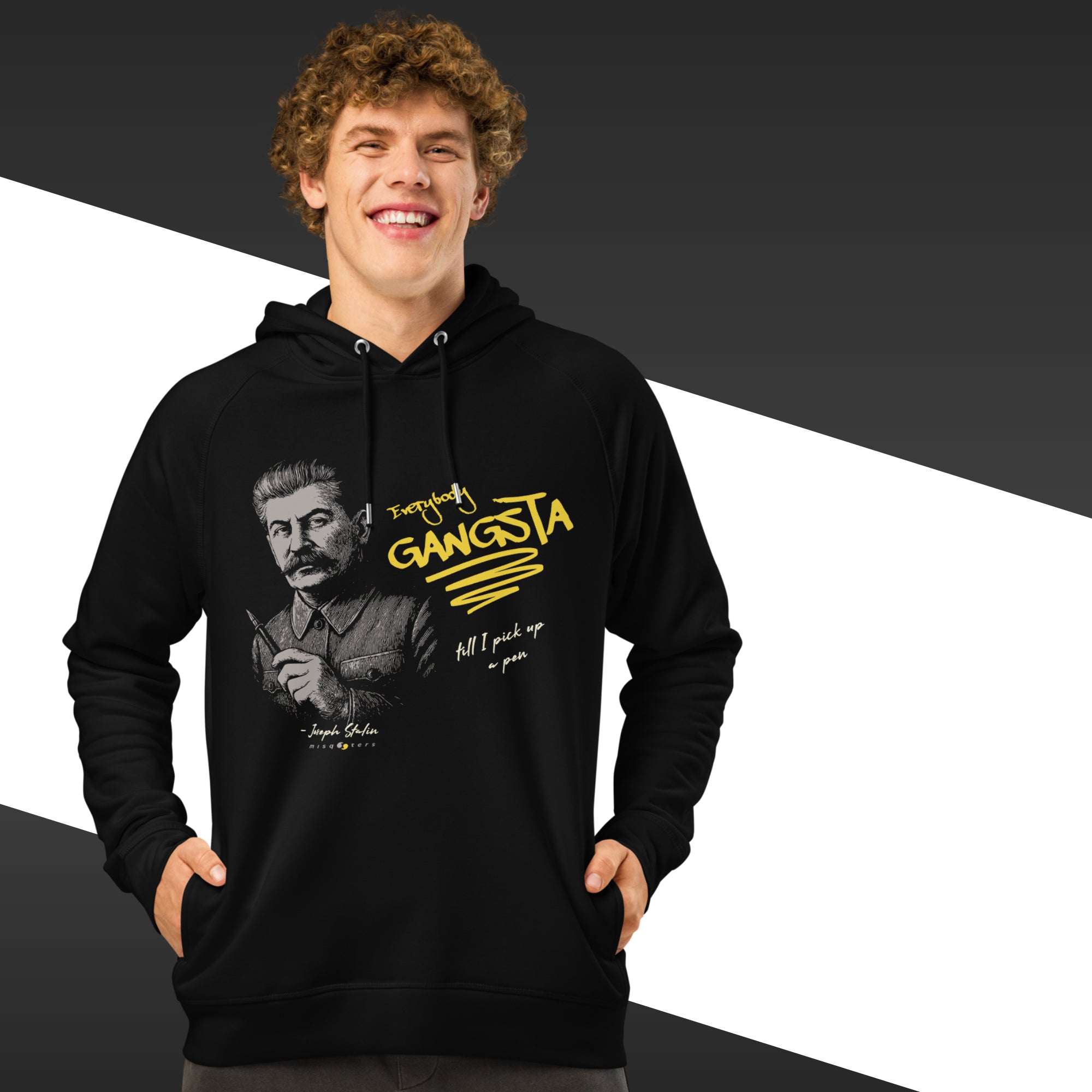 Man wearing a black hoodie with yellow text and graphic design on a black and white background