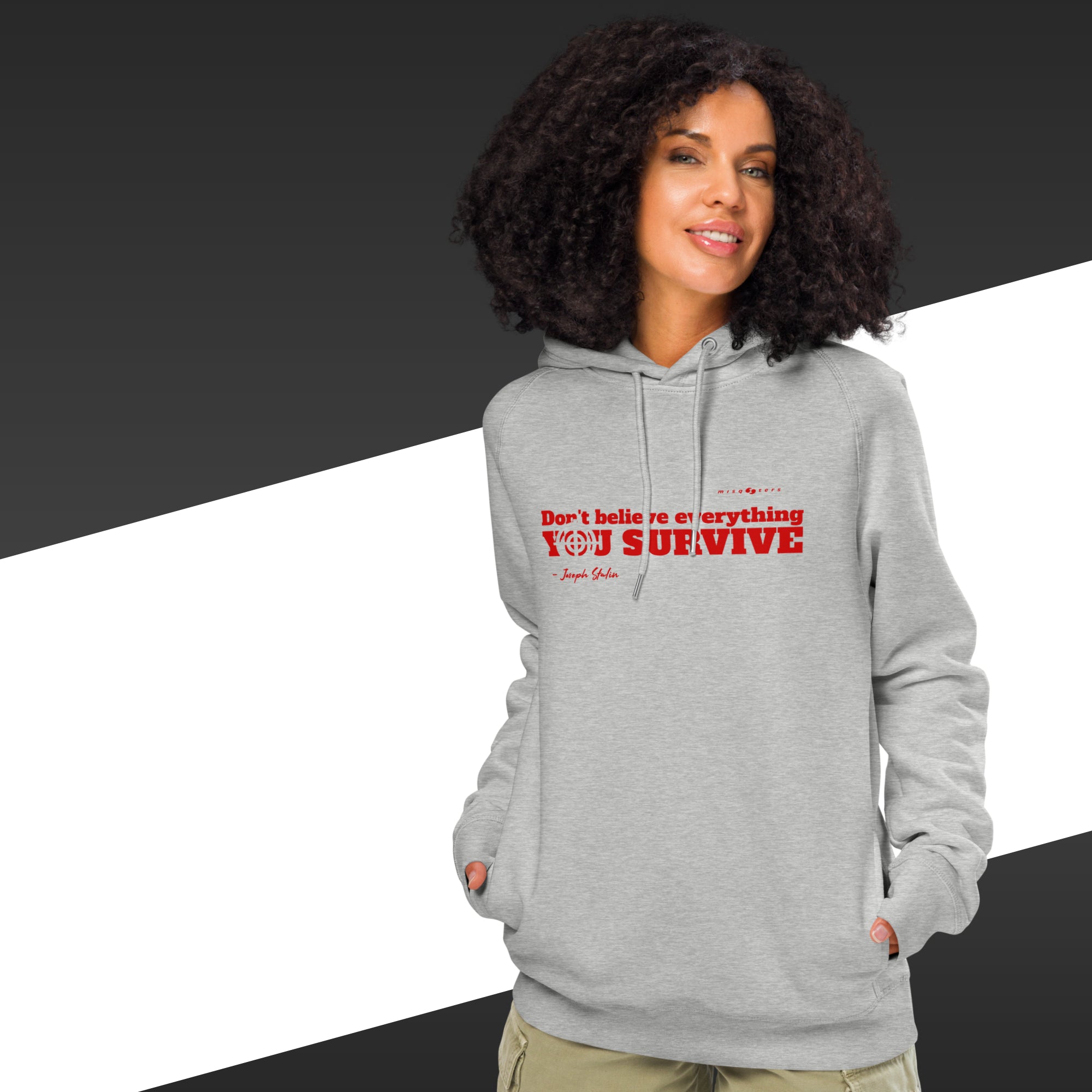Woman with grey hoodie with a red text on and in the background there is black and white stripes