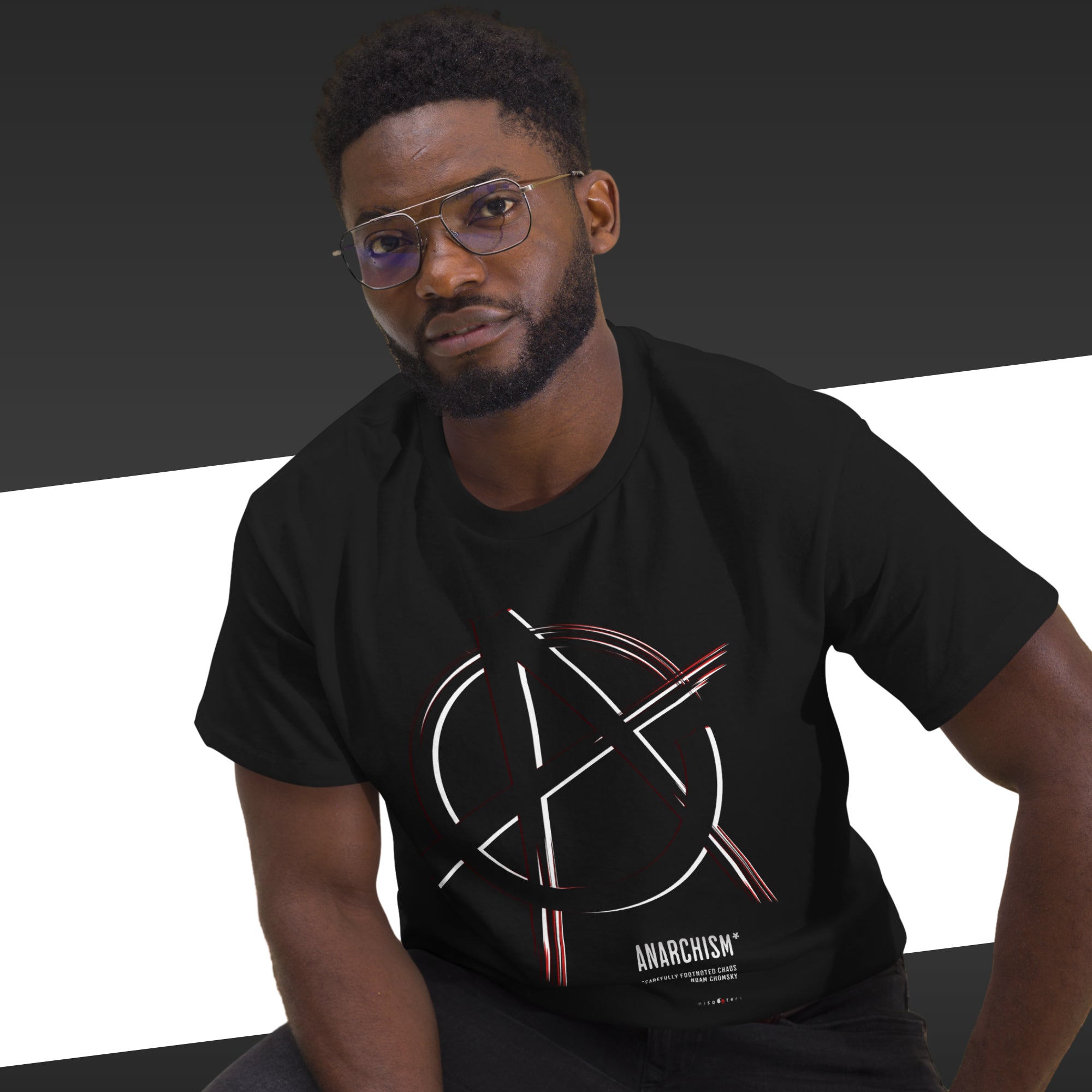 Man wearing a black t-shirt with an anarchist symbol design on a dark background