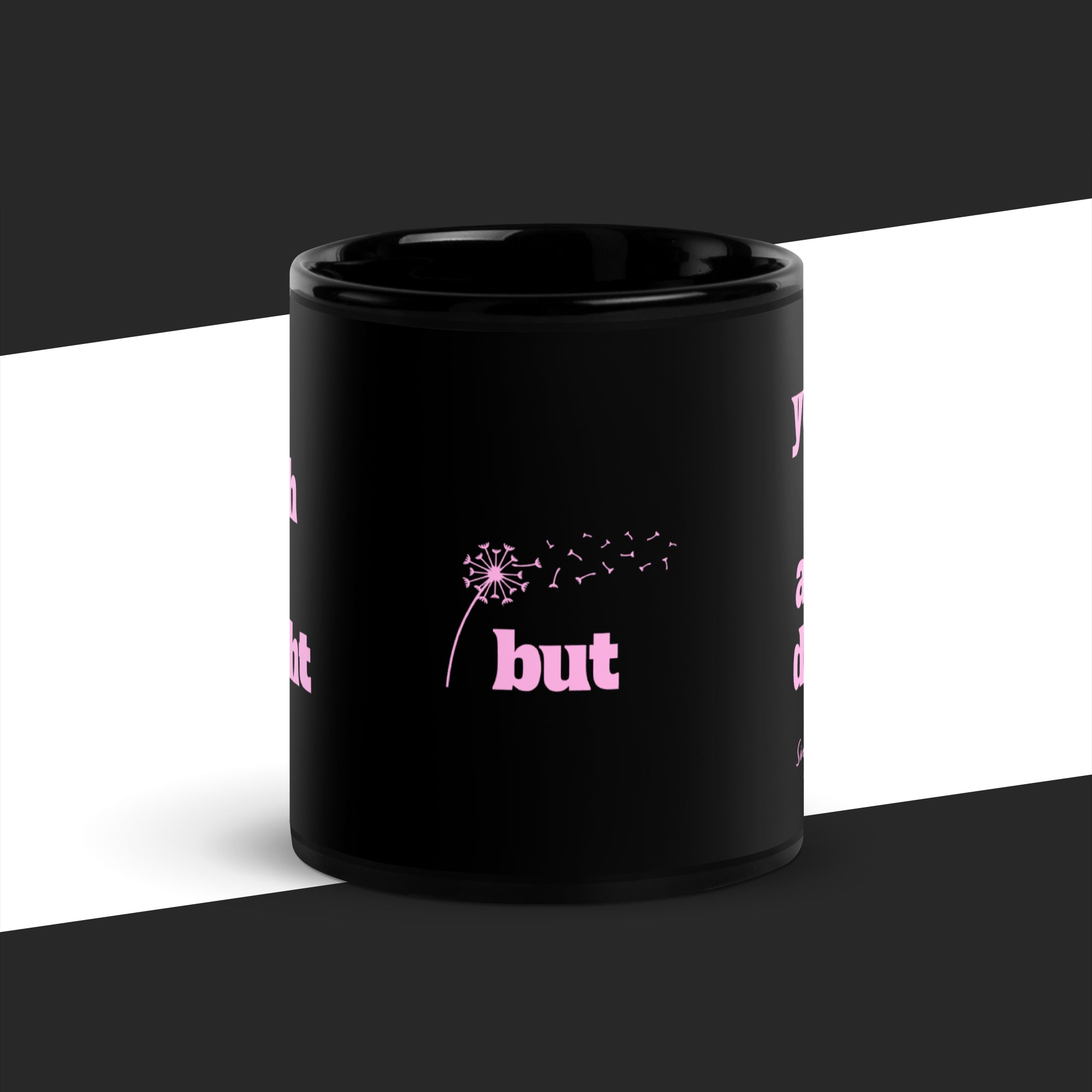 Black mug with pink text and graphics on a white and black background