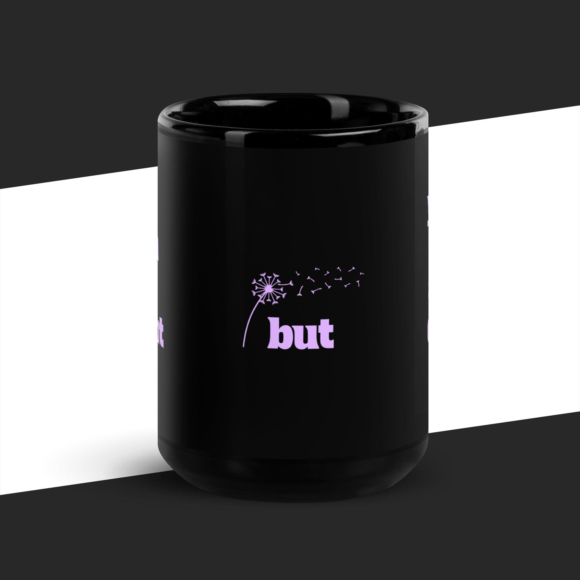 Black mug with a dandelion graphic and 'but' text on a black and white background