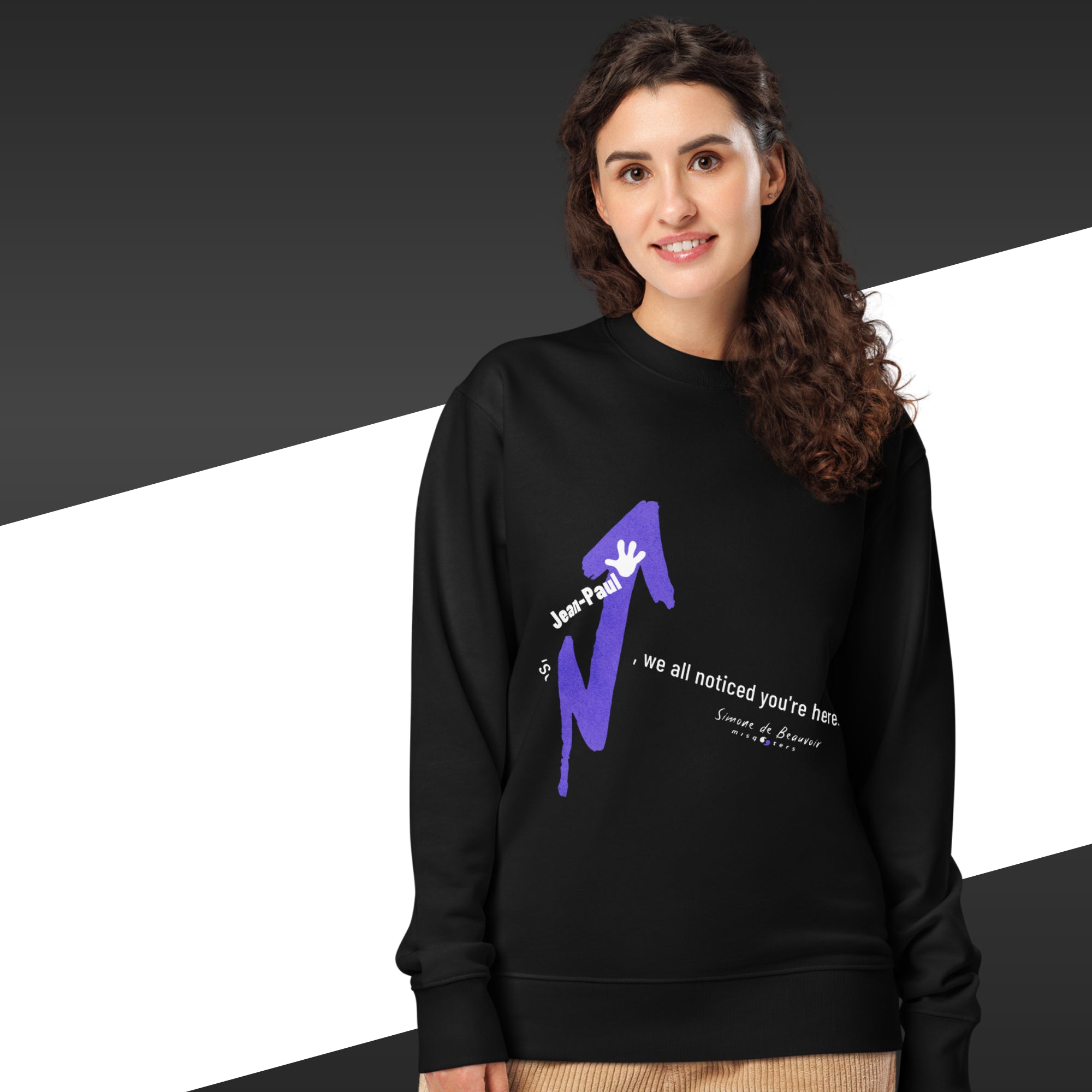 Woman wearing a black sweatshirt with a purple and white graphic design on a black and white background