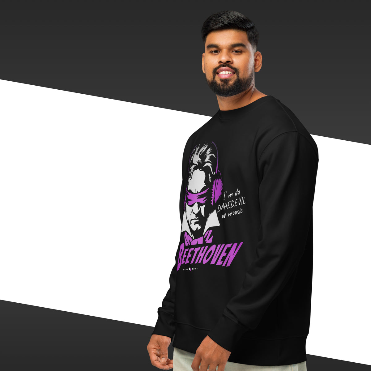 Man wearing a black sweatshirt with a graphic design on a white and black striped background