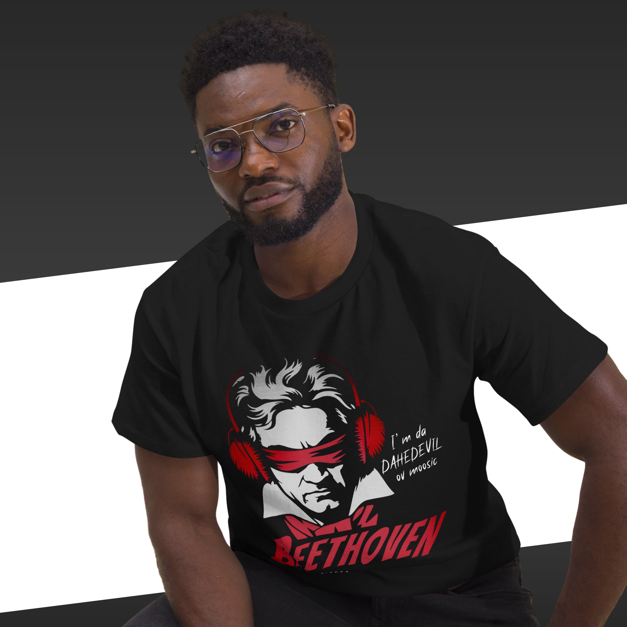 Man wearing a black t-shirt with a graphic design of Beethoven, sitting against a black and white background.