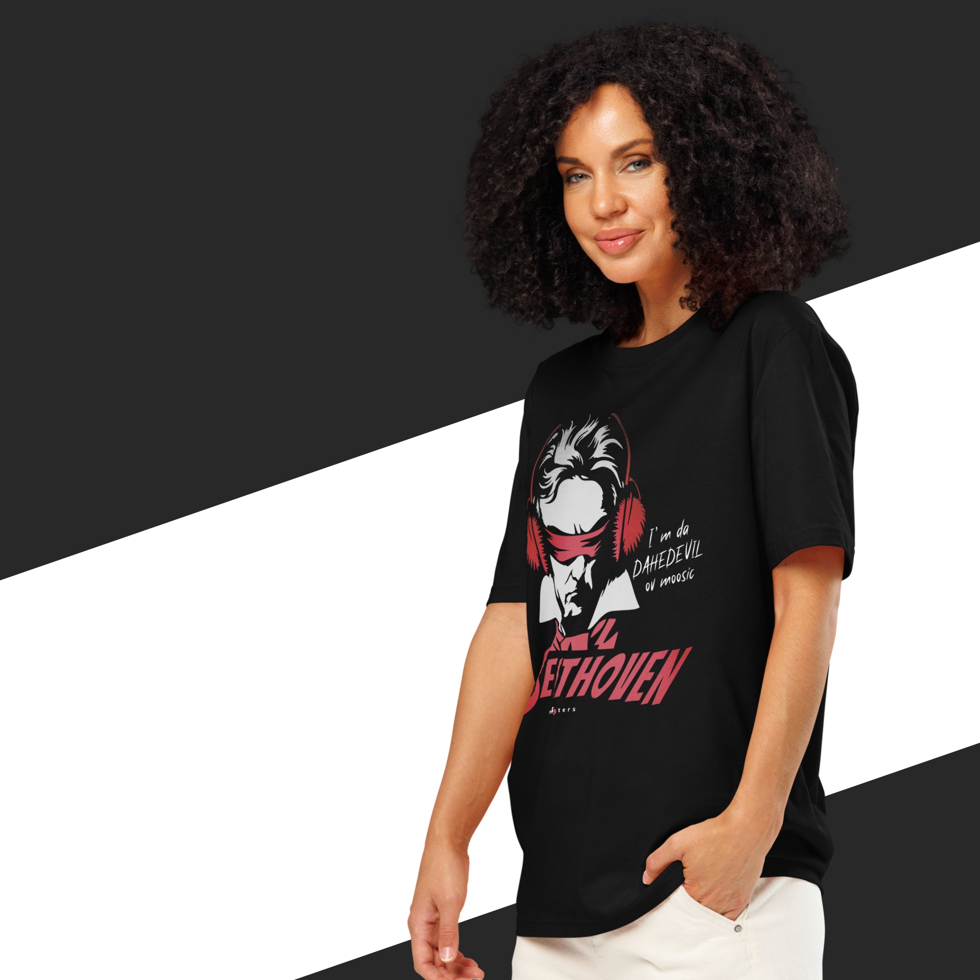 Woman wearing a black t-shirt with a graphic design and text, standing against a black and white background.