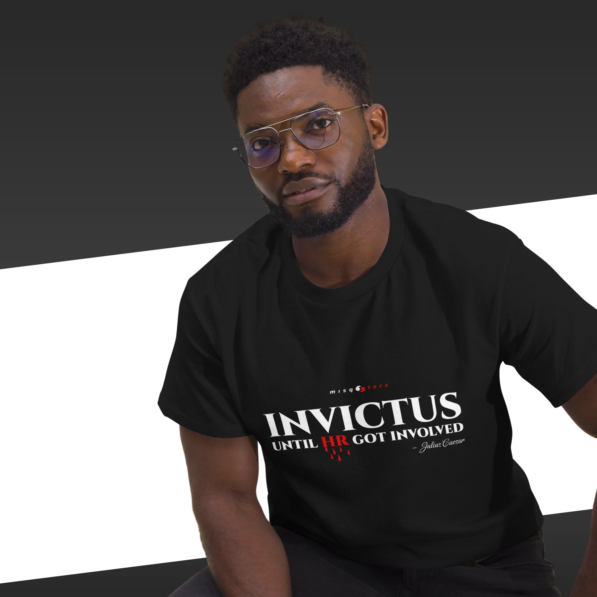 Man wearing a black t-shirt with 'INVICTUS' text on a dark background