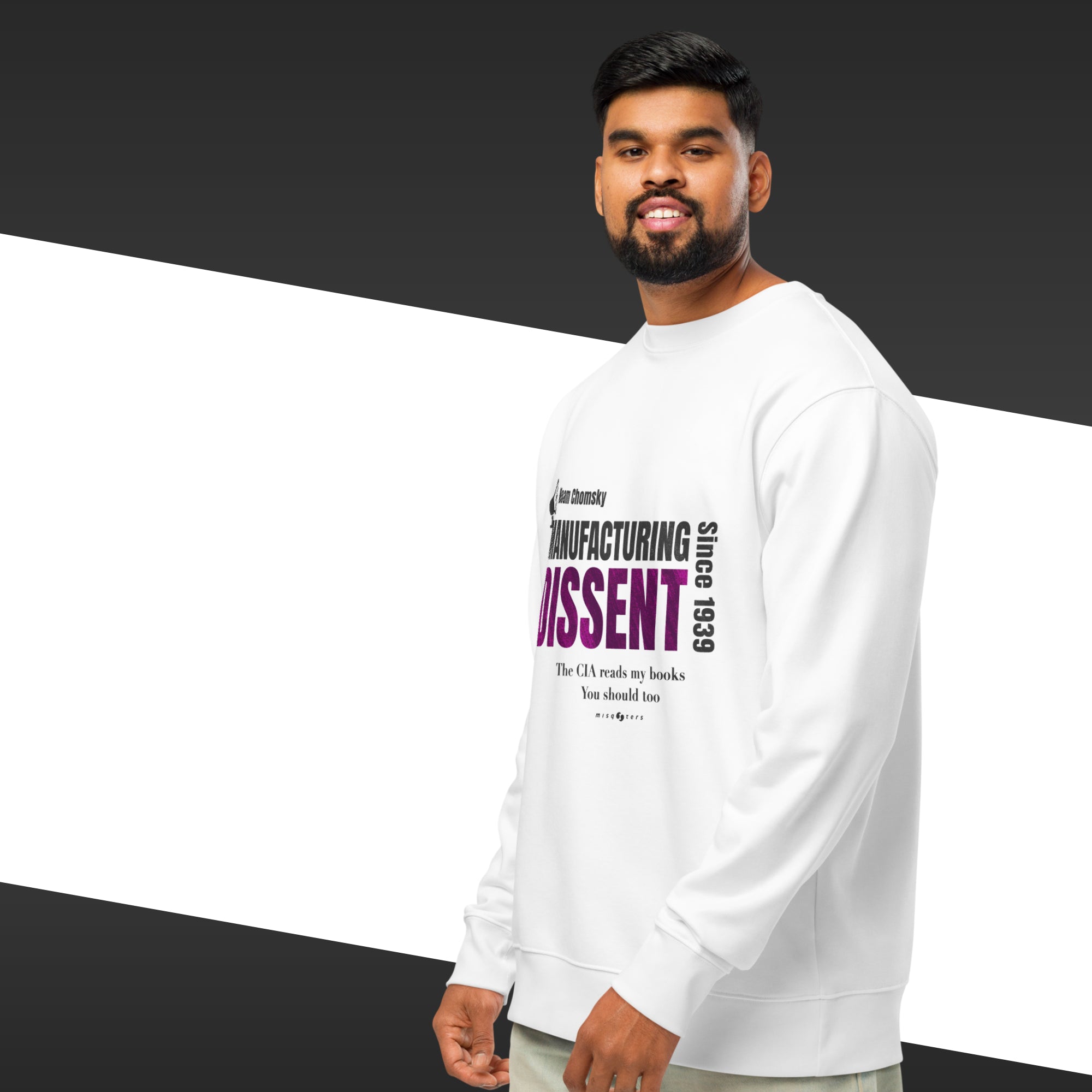 Man wearing a white sweatshirt with the quote "manufacturing dissent" from Noam Chomsky in purple