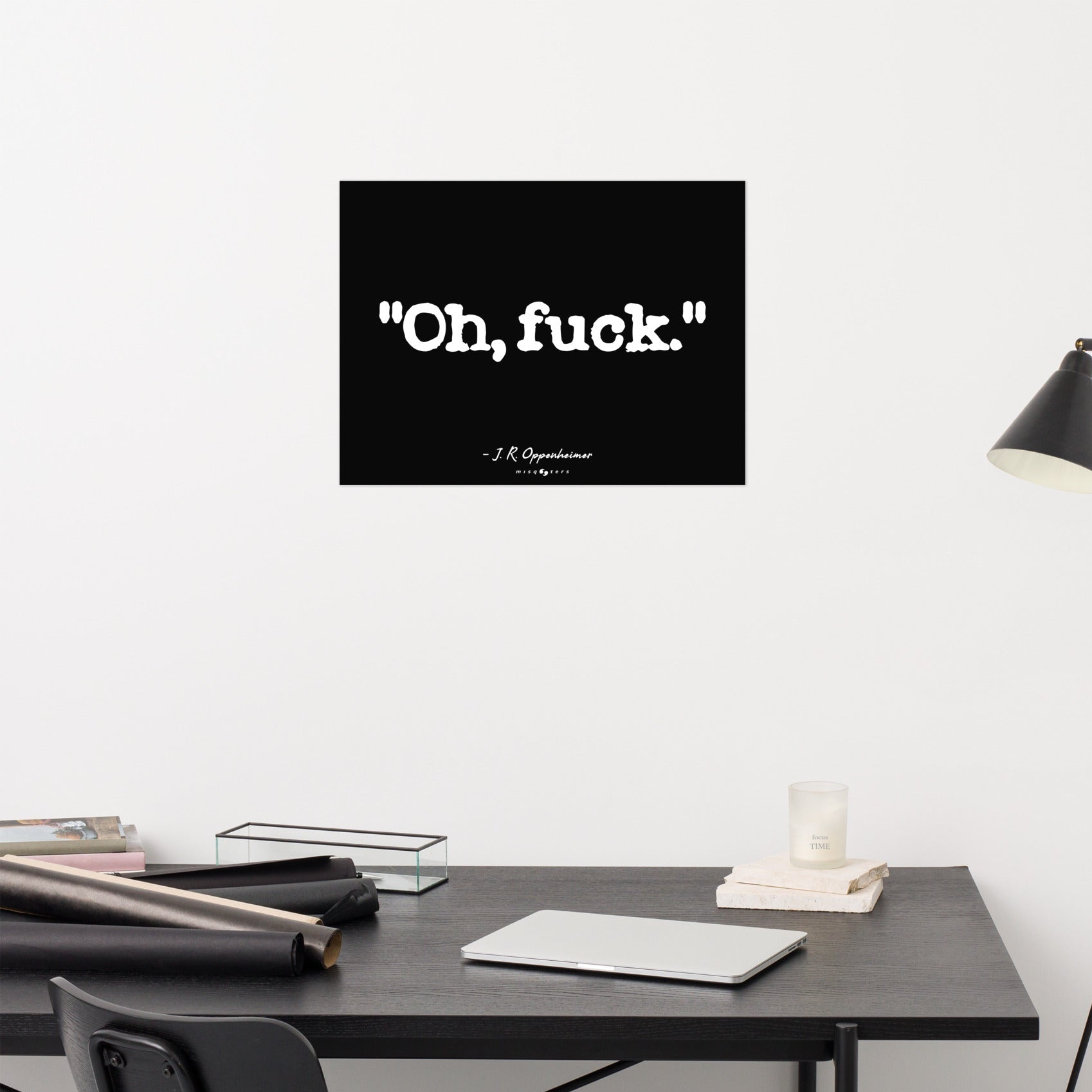Black framed poster with 'Oh, fuck.' text on a white wall above a desk.