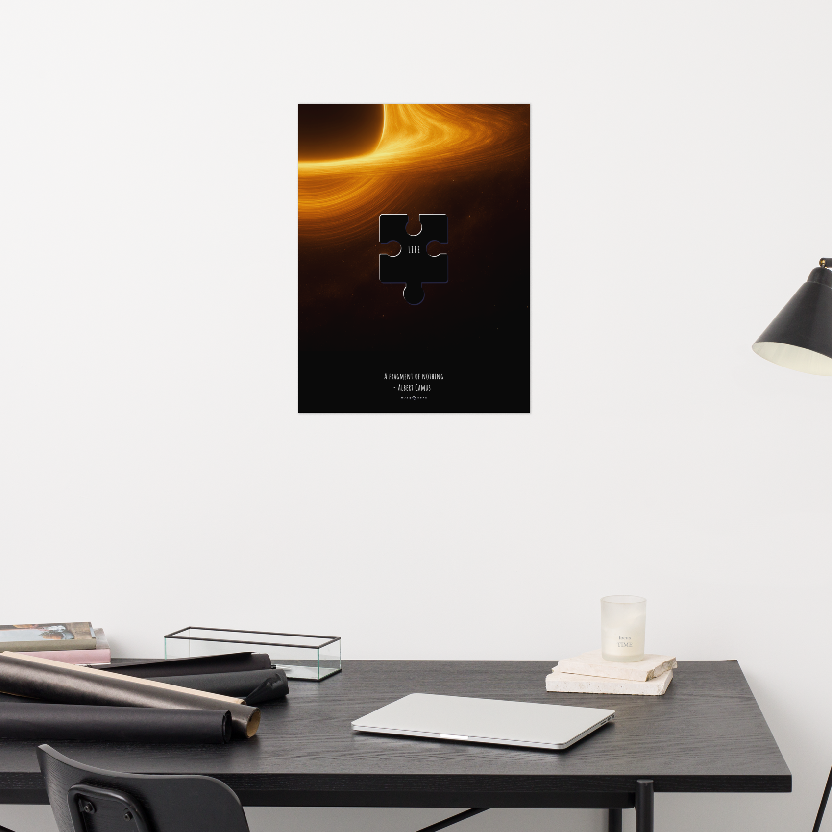 Poster of a black hole with a puzzle piece on a wall above a desk.