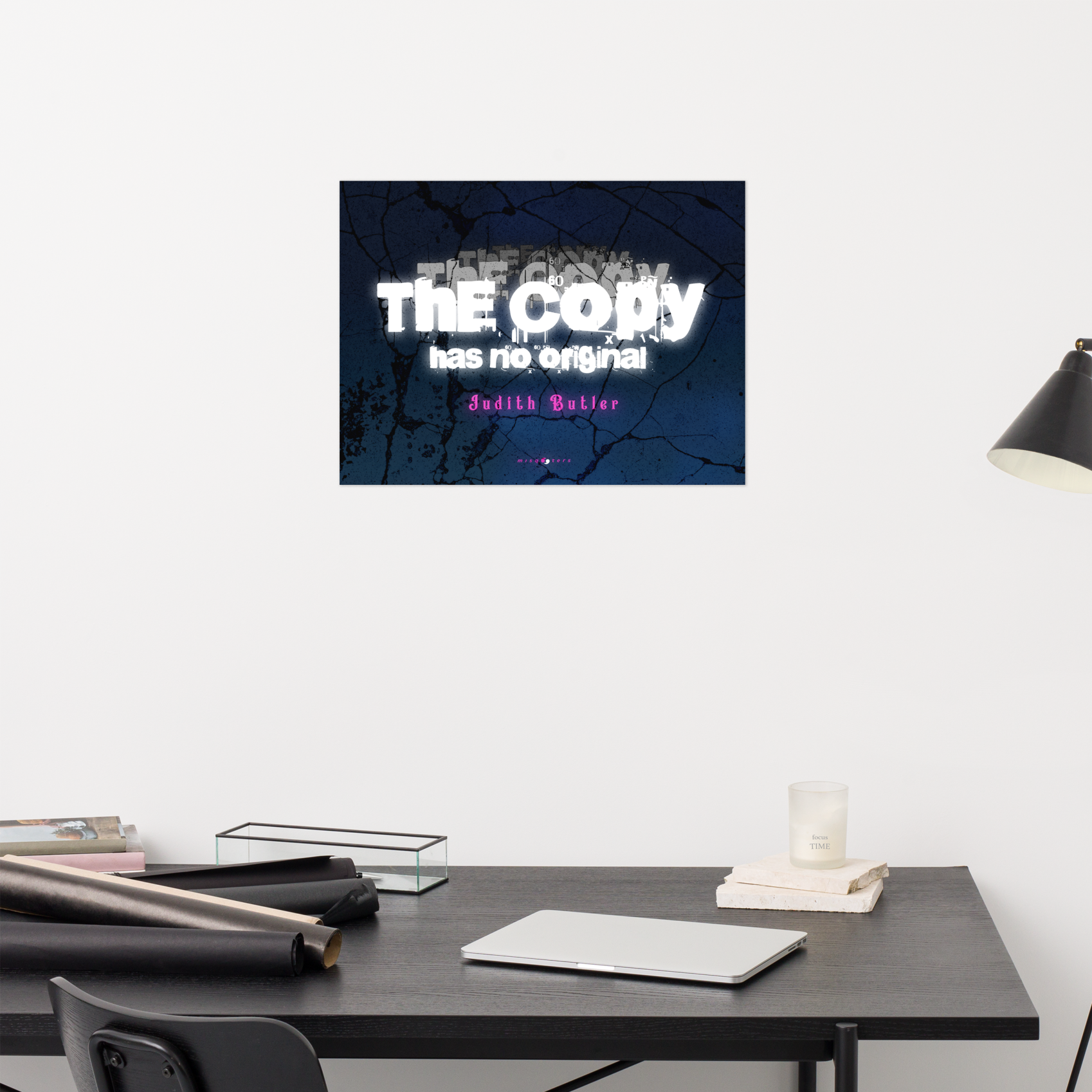 Desk with books and a lamp, featuring a framed quote on the wall.
