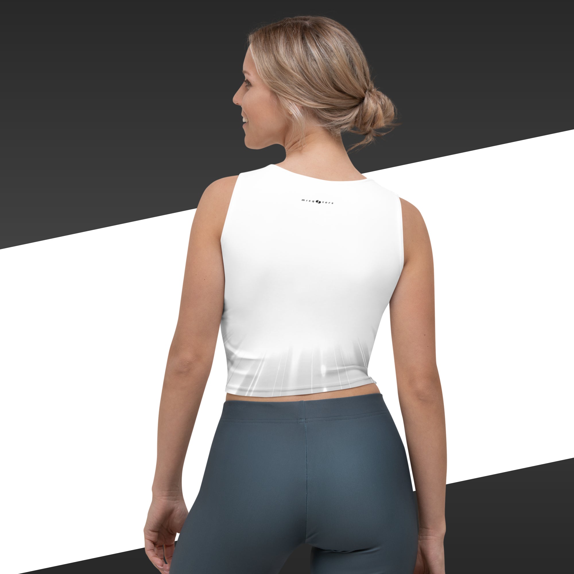 Woman wearing a white sleeveless top and dark gray leggings on a black and white background