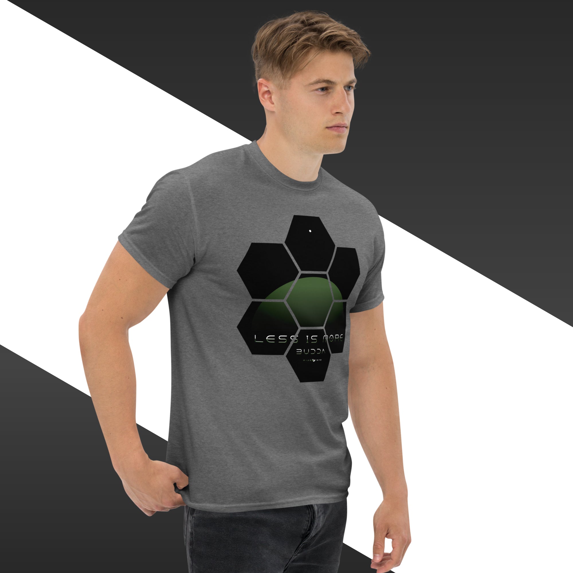 Man wearing a gray t-shirt with a black and green geometric design on a white and black striped background