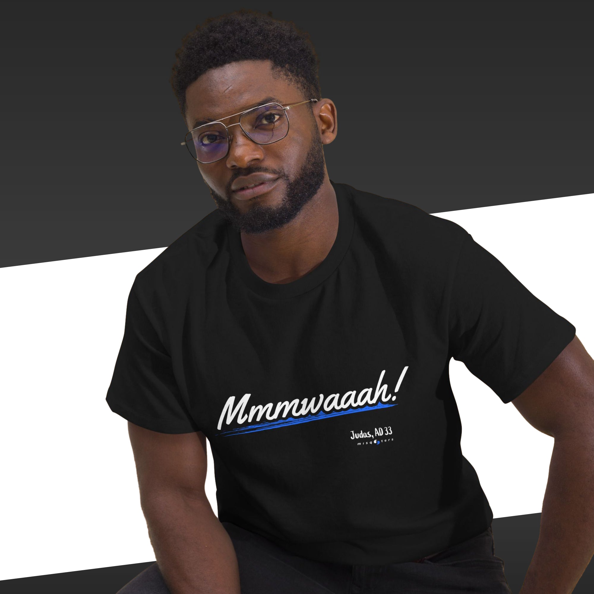 Man wearing a black t-shirt with 'Mmmwaaah!' text on a black and white background