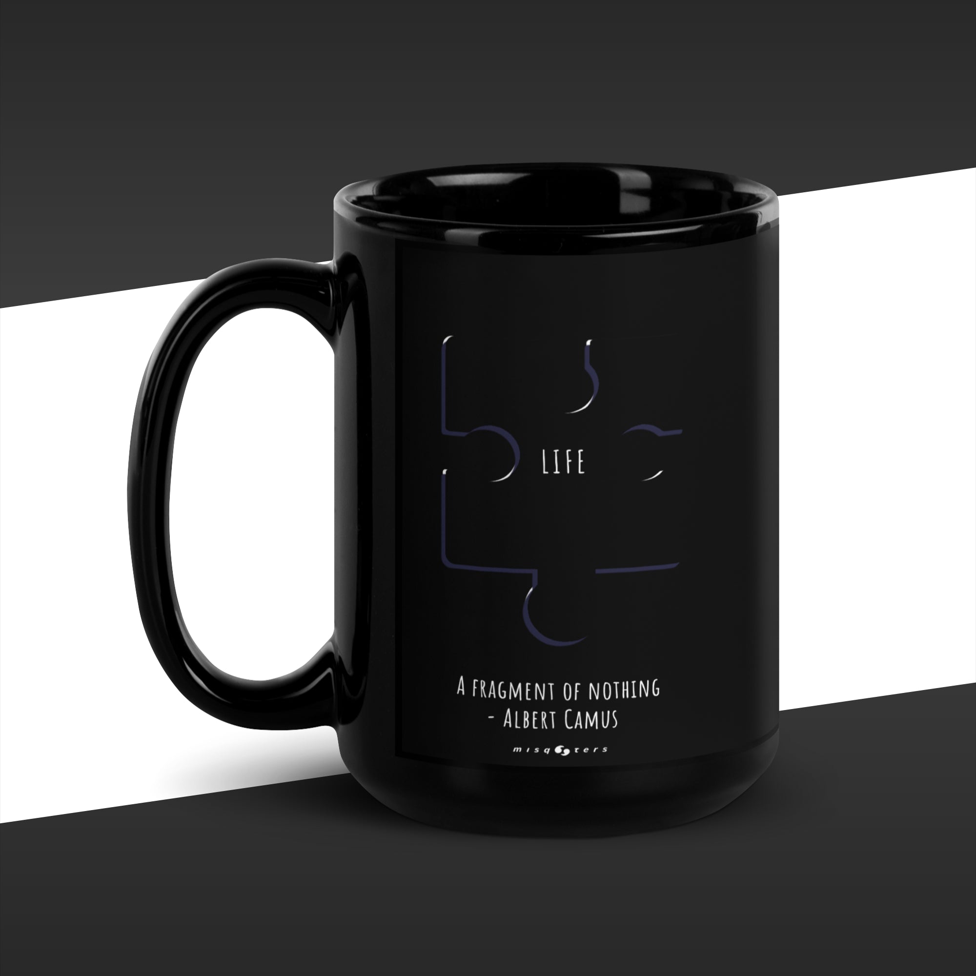 Black mug with abstract design of a puzzle with the work "Life" on it and the fake quote "A fragment by nothing" by Albert Camus below