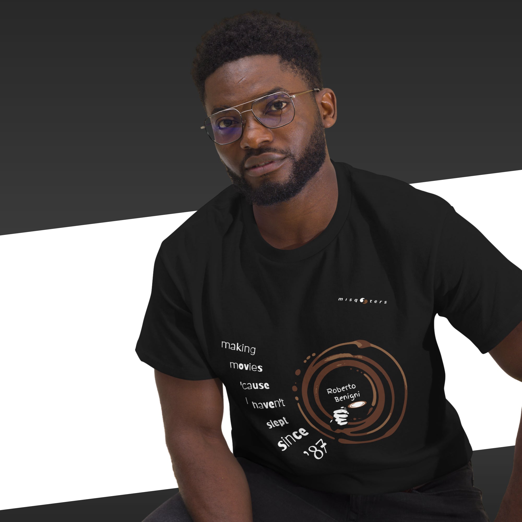 Man wearing a black t-shirt with text and graphics on a dark background
