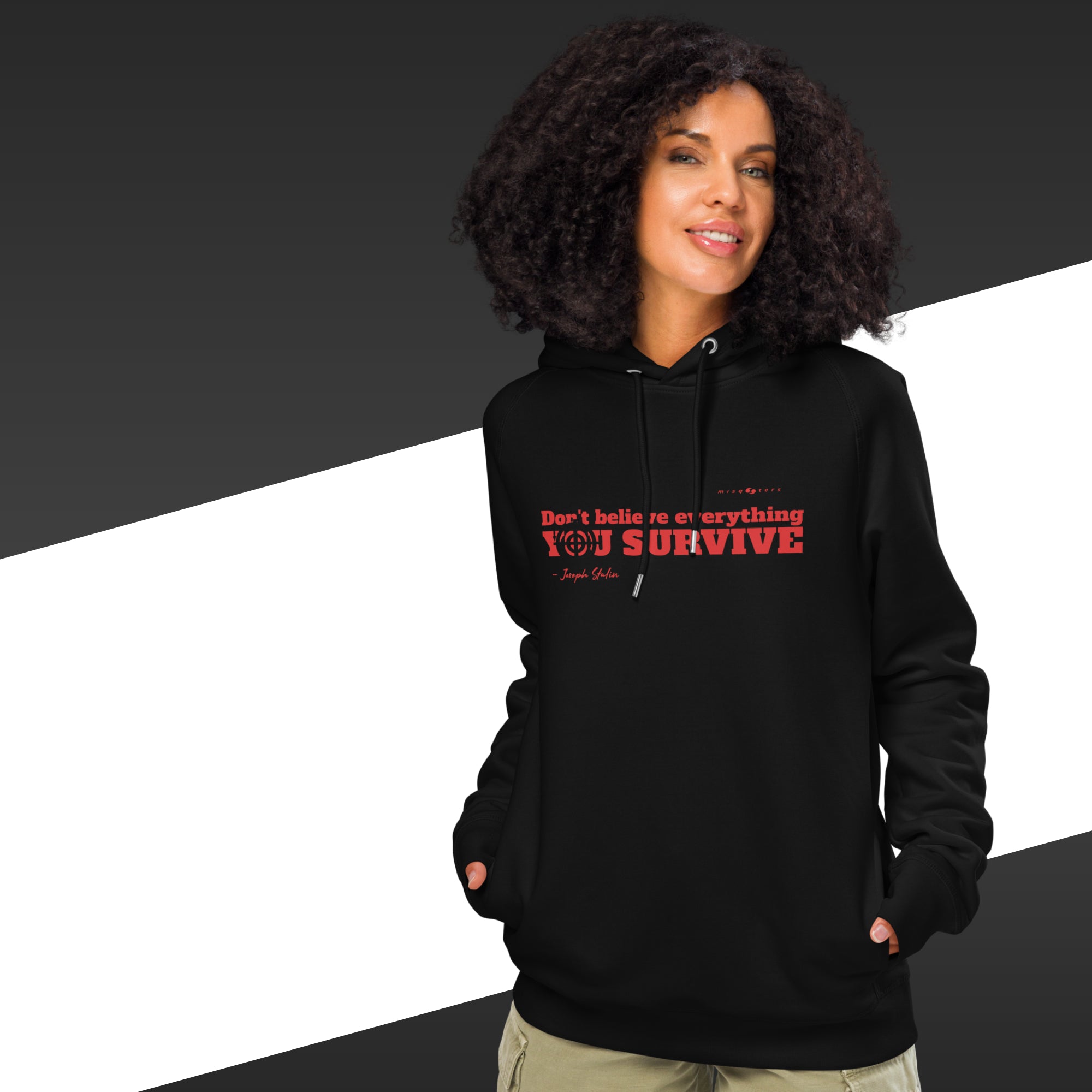 Woman with black hoodie with a red text on and in the background there is black and white stripes