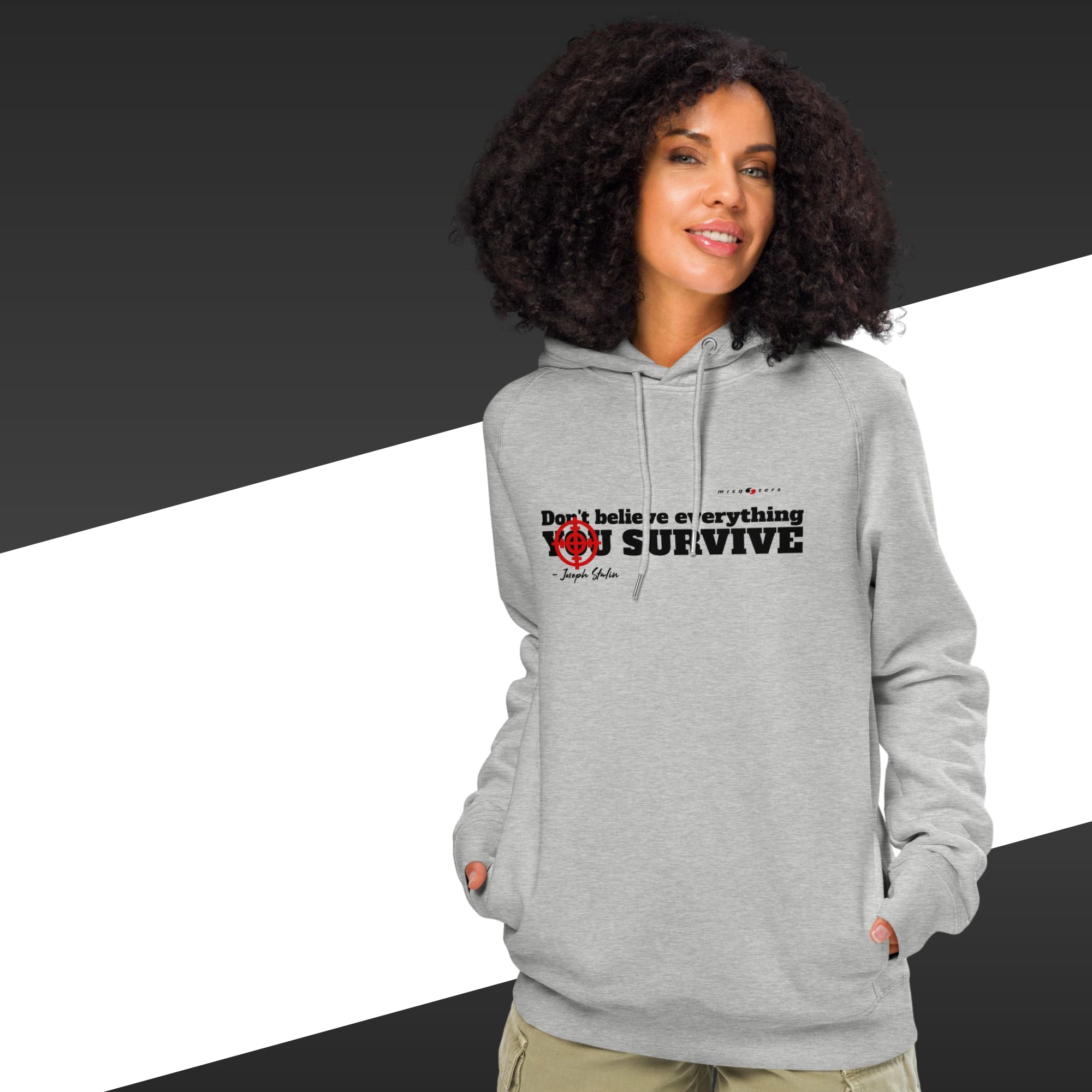 Woman with grey hoodie with a black text on and in the background there is black and white stripes